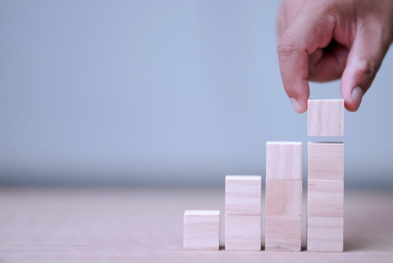 hand holding and arranging wood block stacking as step stair
