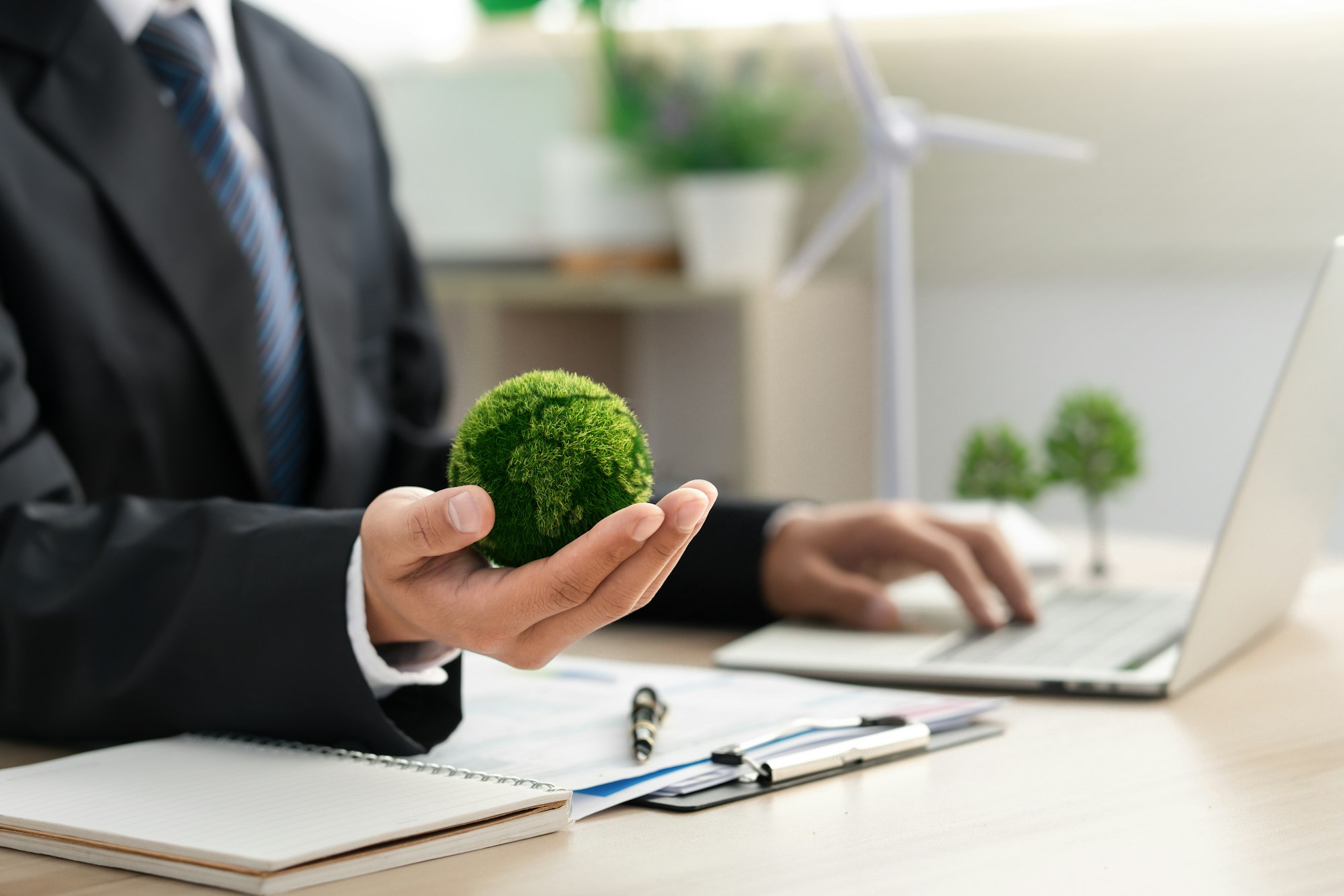 Businessman holds a green ball globe. ESG concept. Environmental, social and governance